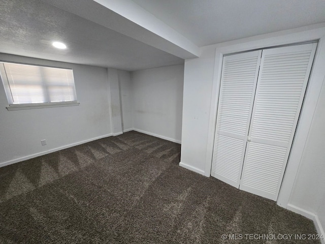 basement featuring dark colored carpet