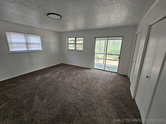 unfurnished room with carpet floors and a textured ceiling