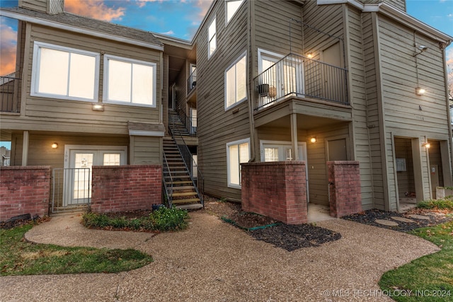 property exterior at dusk featuring a balcony