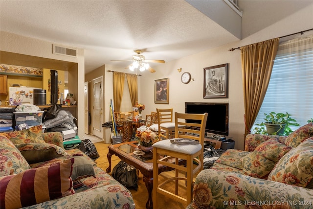 carpeted living room with ceiling fan and a textured ceiling