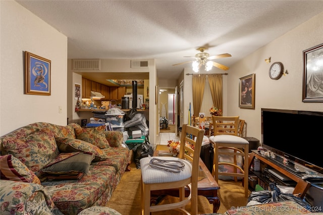 living room featuring ceiling fan and a textured ceiling