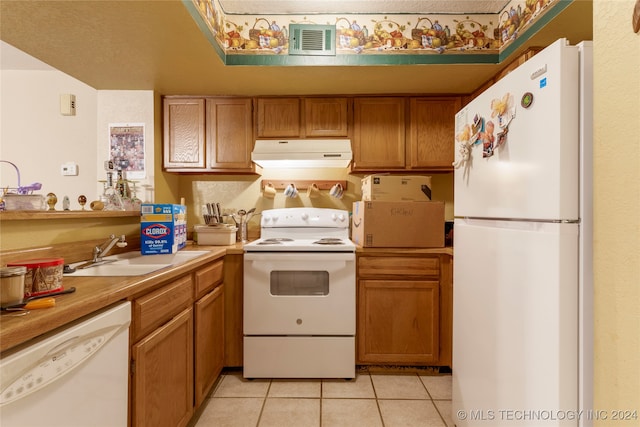 kitchen with white appliances, sink, and light tile patterned floors