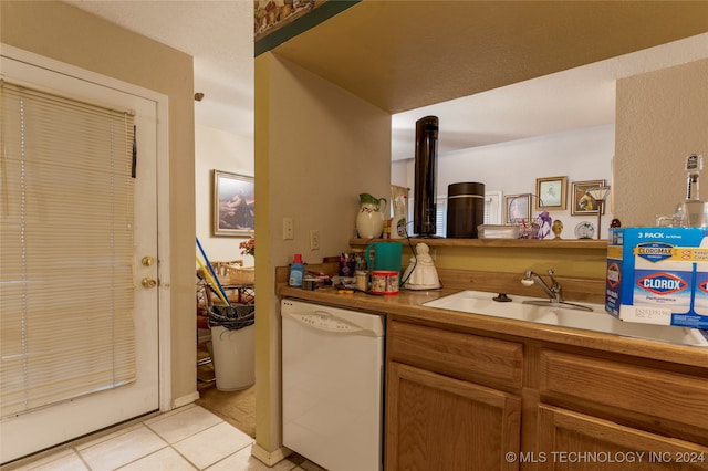 kitchen featuring light tile patterned floors, white dishwasher, and sink