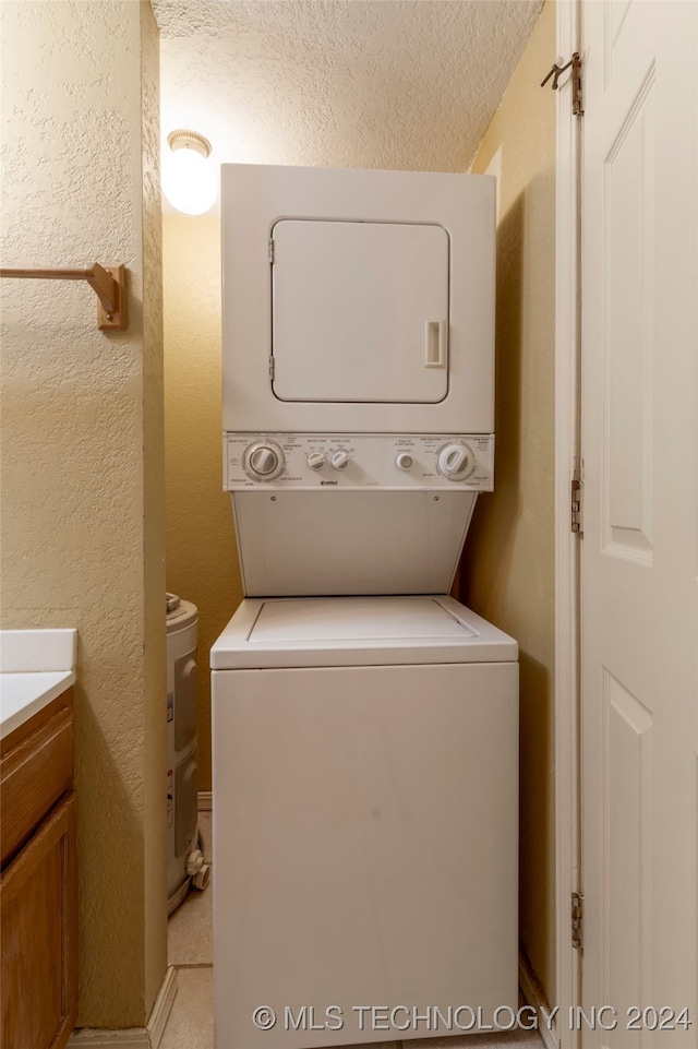 laundry area featuring a textured ceiling and stacked washer and clothes dryer