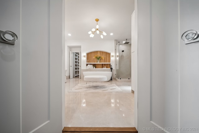 bathroom featuring a washtub and an inviting chandelier