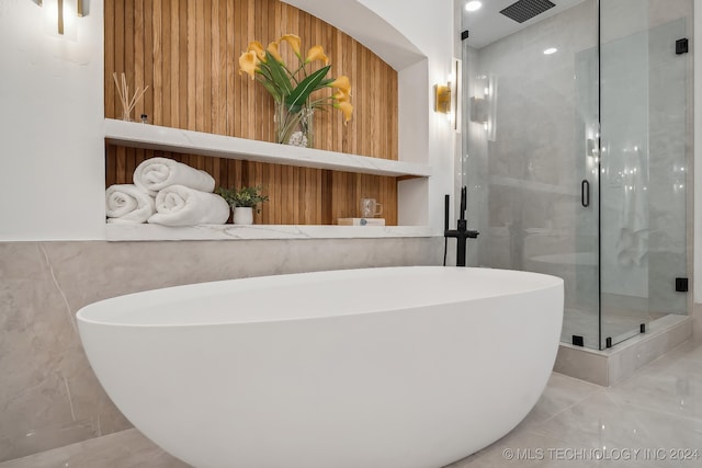 bathroom featuring shower with separate bathtub and wooden walls