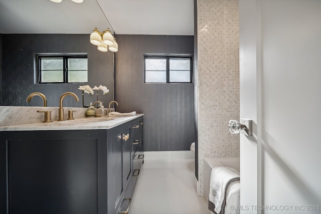 bathroom featuring tile patterned floors, vanity, a healthy amount of sunlight, and a tub to relax in