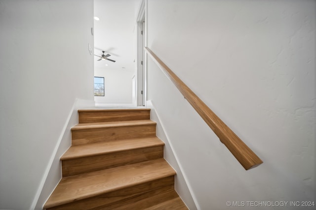 staircase featuring hardwood / wood-style flooring and ceiling fan