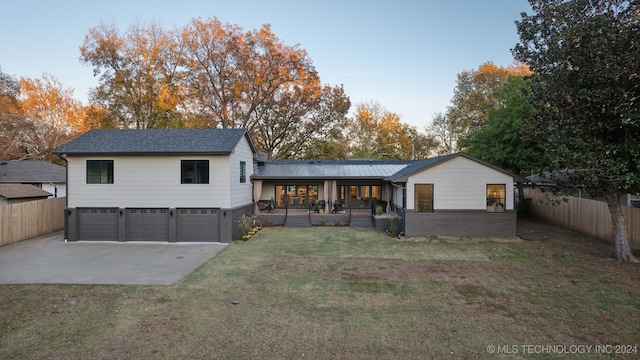 back of house with a lawn, a porch, and a garage