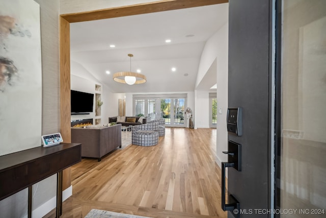 living room with light wood-type flooring and vaulted ceiling