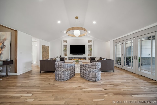 living room featuring french doors, light hardwood / wood-style floors, and lofted ceiling