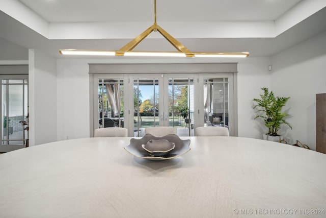 dining area featuring a raised ceiling and french doors