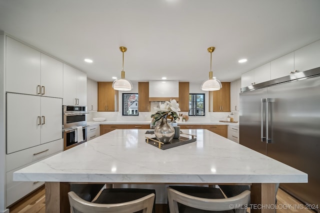 kitchen with white cabinets, a large island, and stainless steel appliances