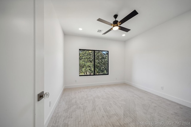 empty room featuring ceiling fan and light colored carpet