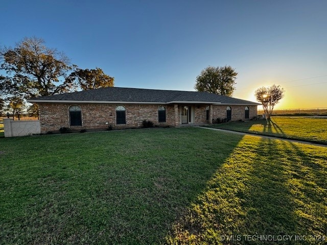 back house at dusk with a lawn