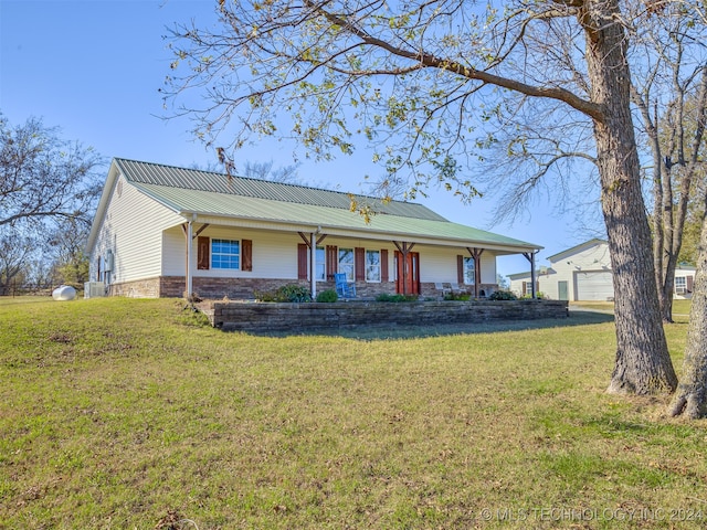 single story home featuring central AC unit, a garage, an outdoor structure, and a front lawn