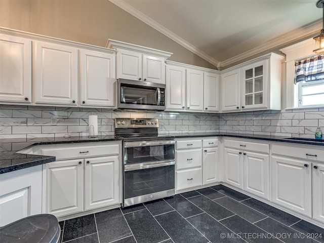 kitchen featuring white cabinets, decorative backsplash, stainless steel appliances, and lofted ceiling