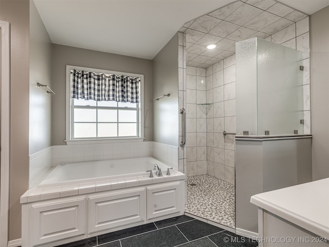 bathroom featuring tile patterned flooring and shower with separate bathtub