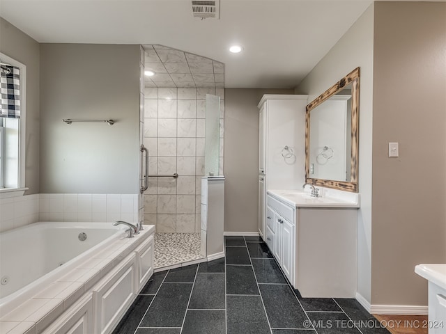 bathroom with vanity and shower with separate bathtub