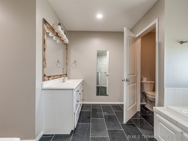 bathroom featuring a tub, vanity, and toilet