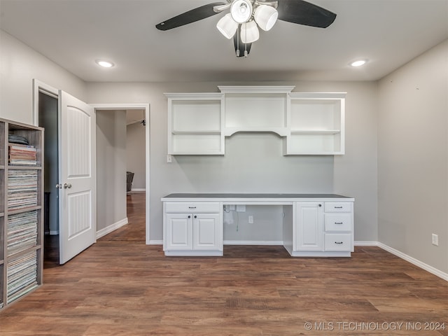 kitchen with white cabinets, dark hardwood / wood-style floors, ceiling fan, and built in desk