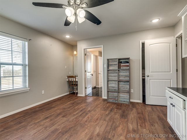 unfurnished bedroom featuring ceiling fan, dark wood-type flooring, and a closet