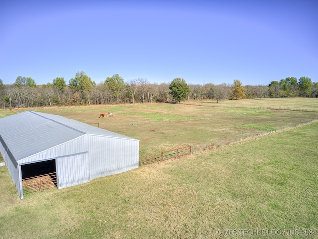 view of yard with a rural view and an outdoor structure