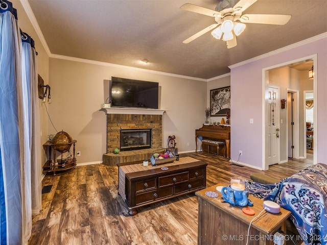 living room featuring a textured ceiling, wood-type flooring, a fireplace, and ornamental molding