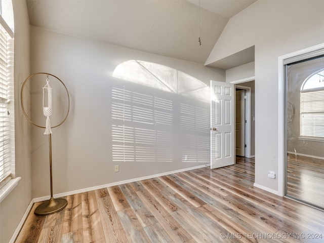 unfurnished bedroom with light hardwood / wood-style flooring and vaulted ceiling