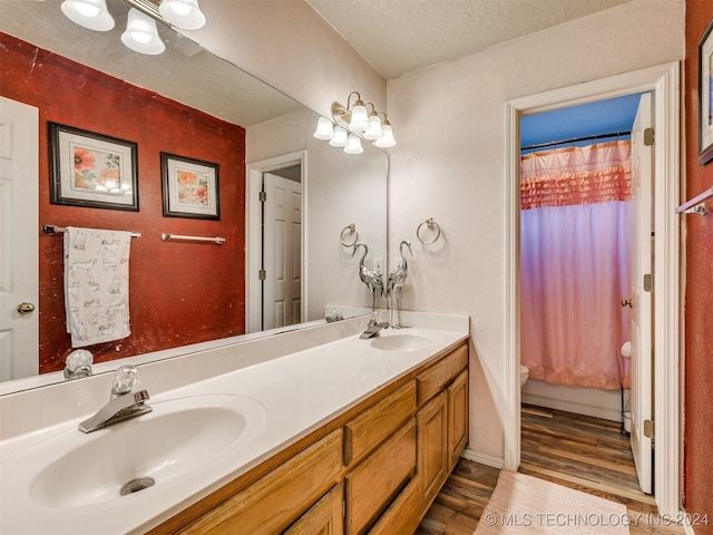 bathroom featuring hardwood / wood-style floors, vanity, a textured ceiling, and toilet