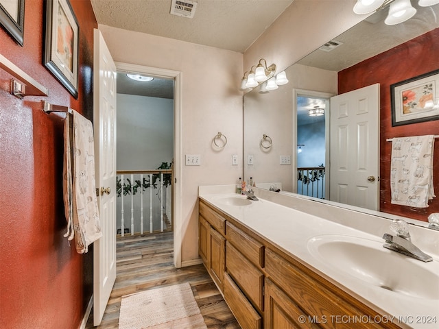 bathroom featuring vanity, wood-type flooring, and a textured ceiling