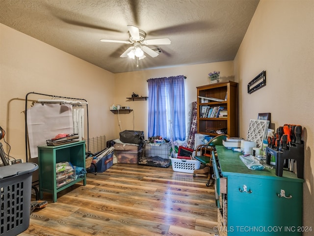 interior space with ceiling fan, wood-type flooring, and a textured ceiling