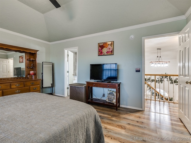 bedroom featuring crown molding, ensuite bathroom, lofted ceiling, and hardwood / wood-style flooring