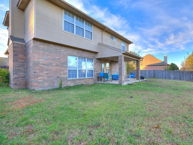 rear view of house featuring a yard and a patio area