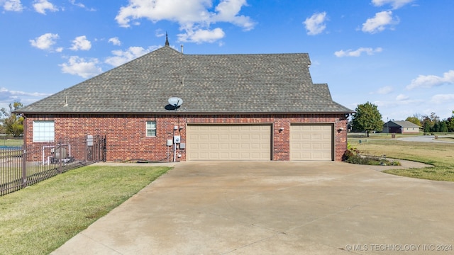 view of side of property featuring a garage and a lawn