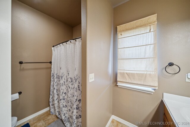 bathroom with toilet, vanity, and walk in shower