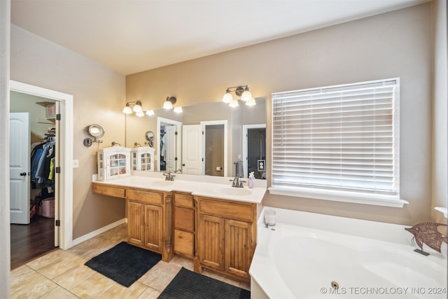 bathroom with tile patterned flooring, vanity, and a tub to relax in