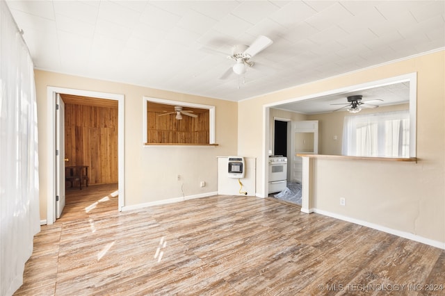 empty room featuring heating unit, light hardwood / wood-style floors, and ornamental molding