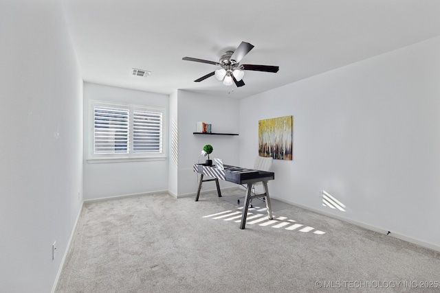 carpeted office featuring ceiling fan