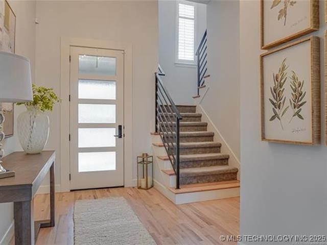 foyer featuring light wood-style floors and stairs