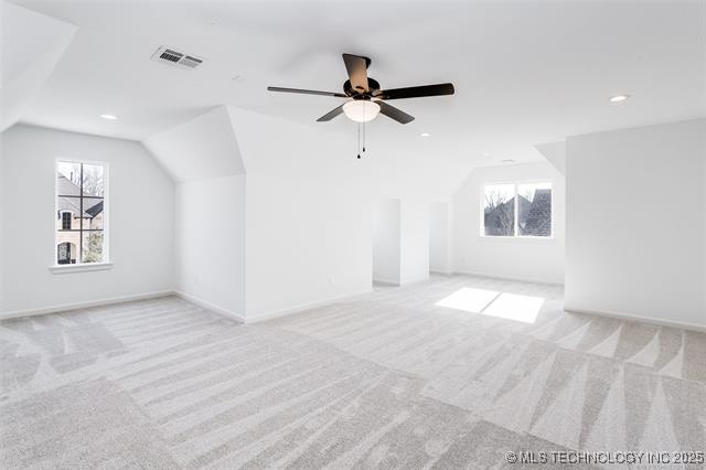 additional living space with ceiling fan, lofted ceiling, and light carpet