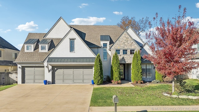 view of front of property featuring a standing seam roof, fence, roof with shingles, concrete driveway, and metal roof