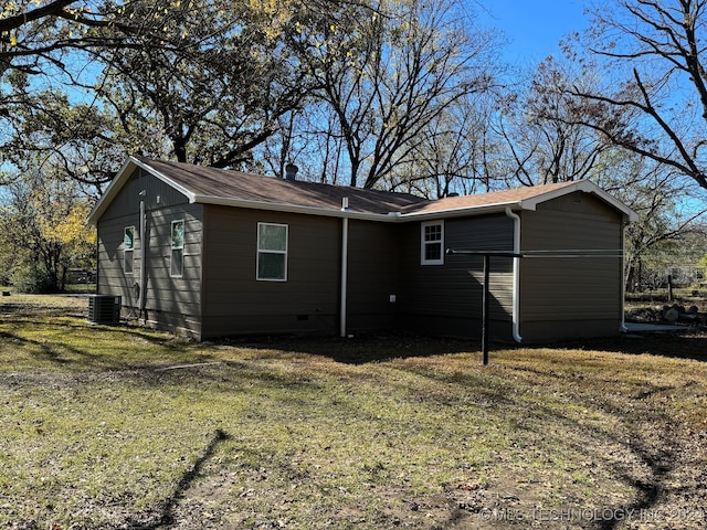 back of house featuring central AC and a lawn