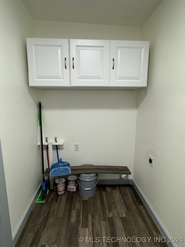 laundry room featuring cabinets, hookup for an electric dryer, and dark wood-type flooring