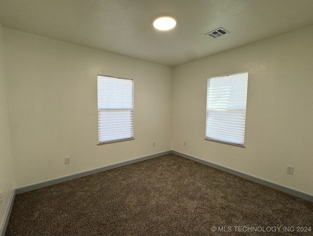 unfurnished room with dark colored carpet