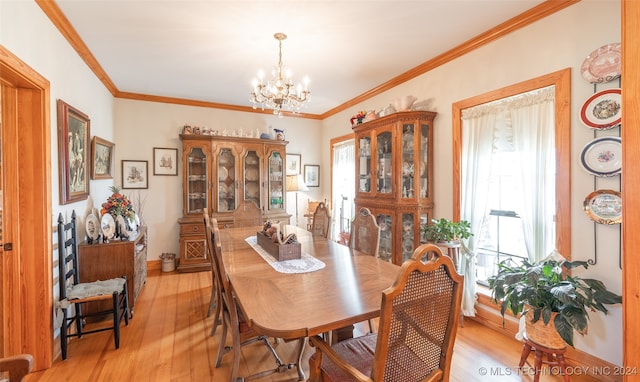 dining area with light wood-type flooring, a wealth of natural light, and crown molding