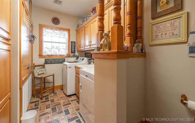 laundry room featuring cabinets and washer and dryer