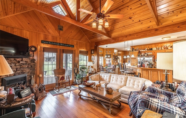 living room with wood-type flooring, high vaulted ceiling, wooden ceiling, beamed ceiling, and wood walls