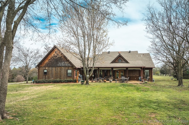 rear view of property with a yard and a patio