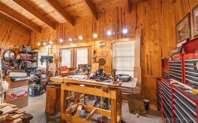 interior space featuring a workshop area, carpet, wooden ceiling, wooden walls, and beam ceiling